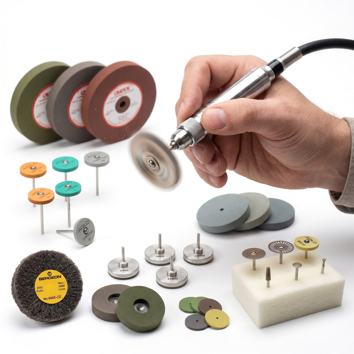 Jeweler's hand spinning a Foredom flex shaft handpiece with Cratex, AGiLO, and Bergeon polishing wheels and rods